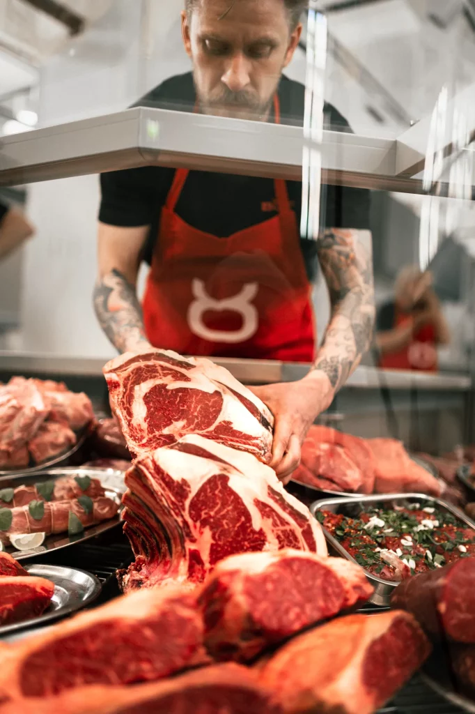 Lihakauppa Böffin lihamestari asettelee pihvikarjan lihaa hallimyymälän lihatiskiin.